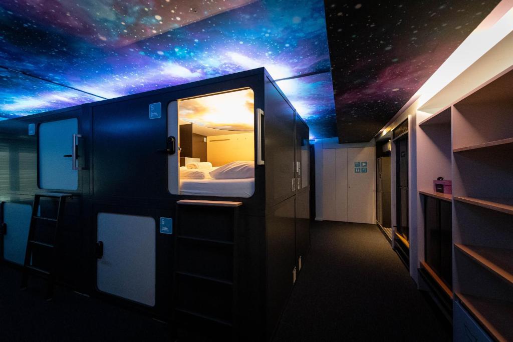 A floor of stacked sleeping berths along a lit corridor.