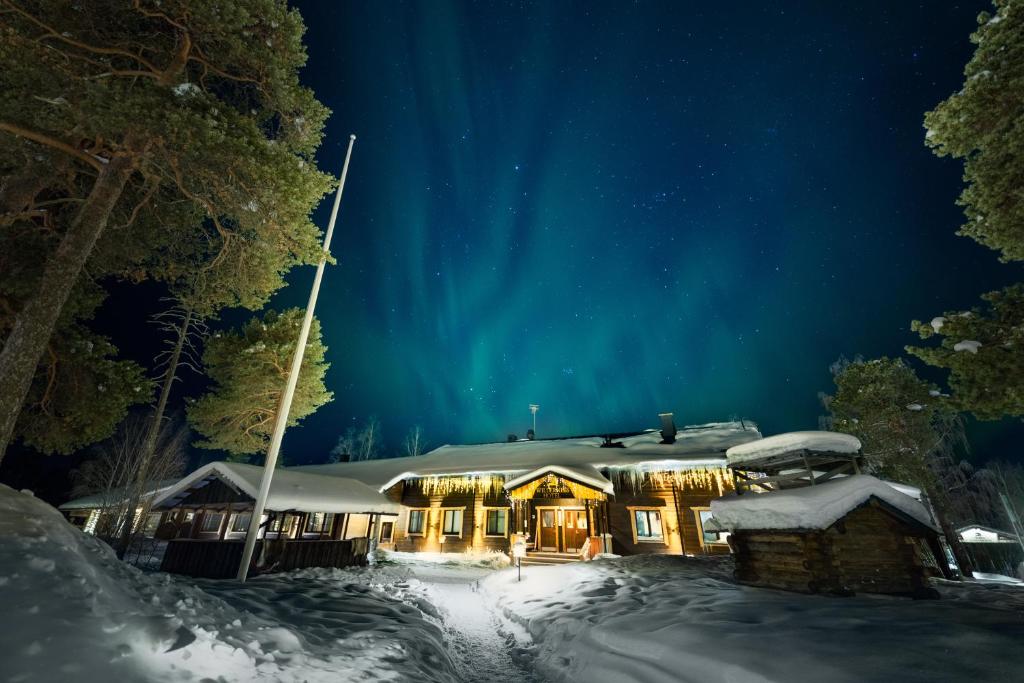 A glazed cabin standing apart among snow-covered pines.